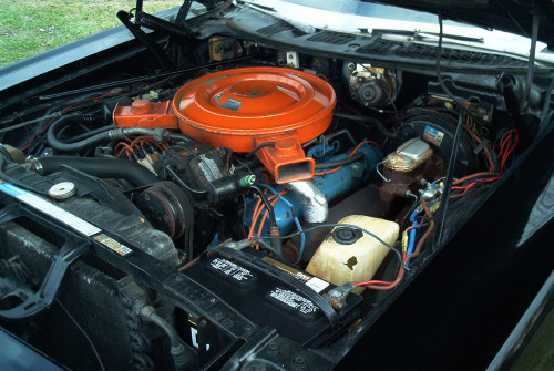 Engine bay with orange round air cleaner over a V8 engine