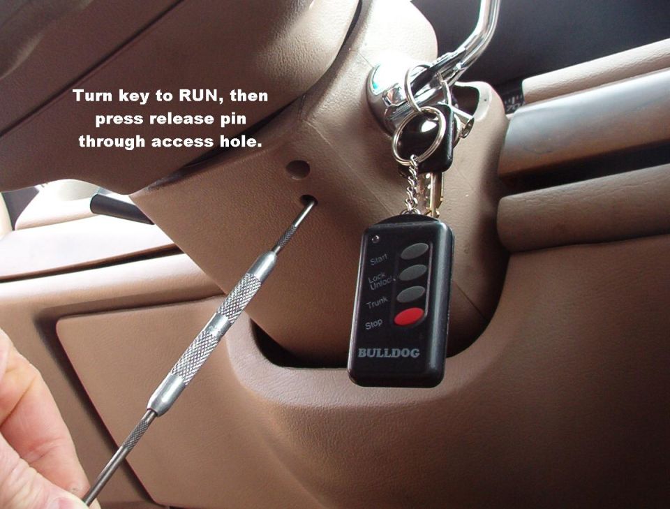 Bulldog alarm fob and key in ignition with pick tool, tan steering column trim