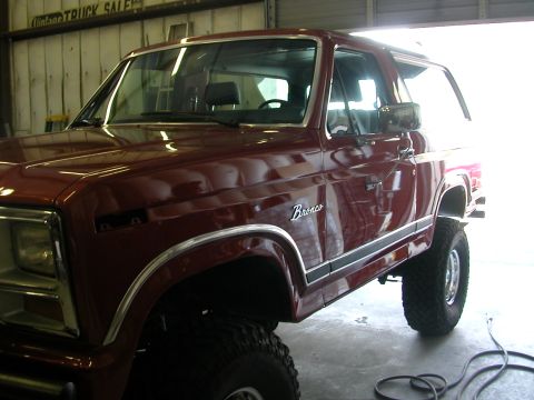 1984 Ford Bronco - This maroon 1984 Ford Bronco features prominent chrome trim and the iconic 'Bronco' script on its side.