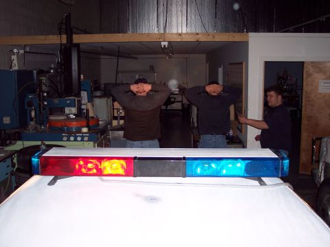 2001 Ford Crown Victoria - A police light bar with red and blue lights is mounted on the roof of a white vehicle.