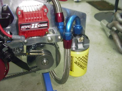 1990 Ford Mustang - Close-up view of engine parts, including an ignition box and oil filter, with braided fuel lines.