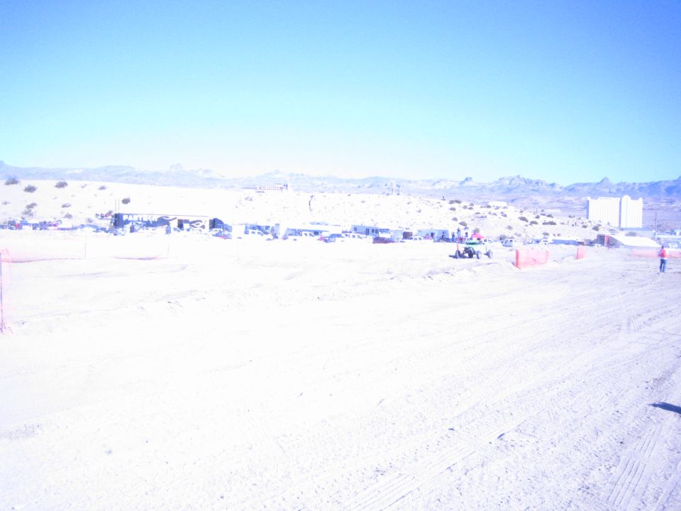 Overexposed wide view of a desert off-road racing course and pits