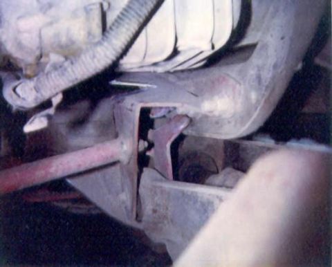 1989 Ford Bronco - Undercarriage view of a vehicle's frame and suspension system, showing mechanical components and rust.