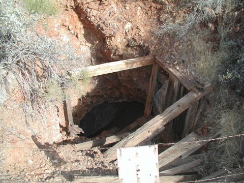 1994 Ford Bronco - A mine shaft entrance is visible, reinforced with weathered wooden beams and surrounded by arid vegetation.
