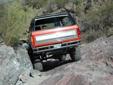 1994 Ford Bronco - This 1994 Ford Bronco is shown off-roading on a rocky trail, demonstrating its capability in challenging environments.