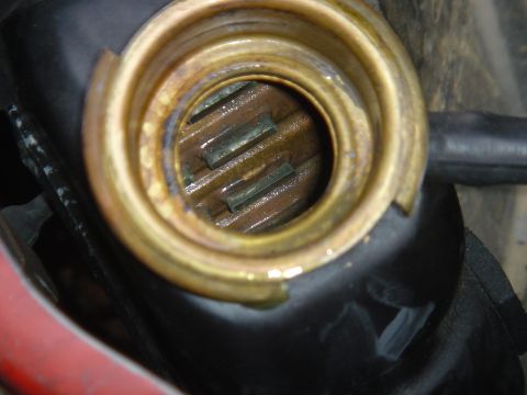 1986 Ford Mustang - Close-up view of a radiator cap opening, revealing the internal fins and some fluid residue.