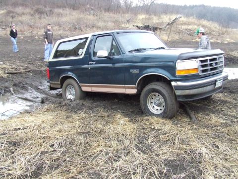 1994 Ford Bronco - A 1994 Ford Bronco is stuck in the mud with onlookers nearby.