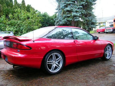 1996 Ford Probe - This red 1996 Ford Probe GT coupe is shown from the rear quarter angle, with a sticker visible on the rear window.