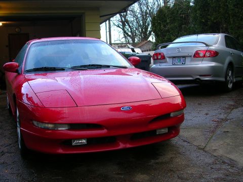 1996 Ford Probe - A red 1996 Ford Probe is parked in a driveway next to a silver Mazda 6.