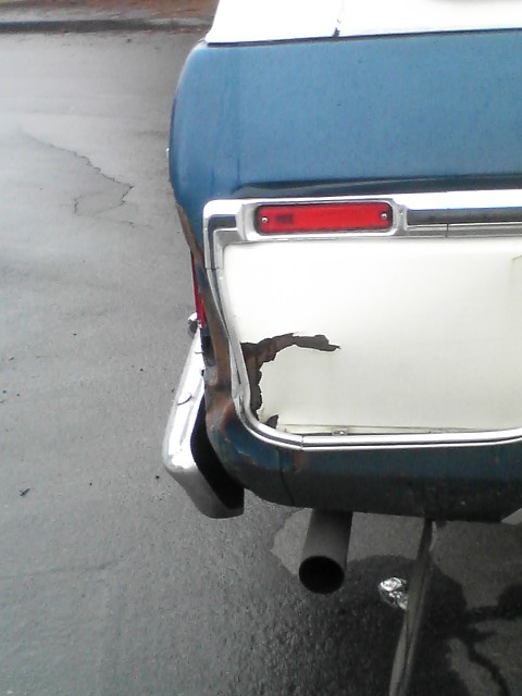 1978 Ford Bronco - Rear view of a 1978 Ford Bronco showing rust damage near the taillight and bumper.