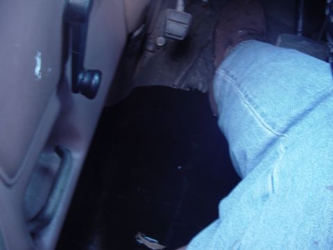 1989 Ford Bronco - View of the driver's side interior, showing the floor, pedals, and door panel.