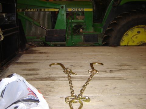 1992 Ford Bronco - A John Deere tractor is partially visible on a wooden trailer, with tie-down chains in the foreground.