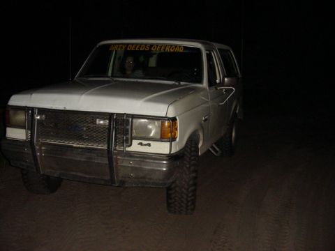 1989 Ford Bronco - White 1989 Ford Bronco parked at night, a brush guard and "DIRTY DEEDS OFFROAD" decal.