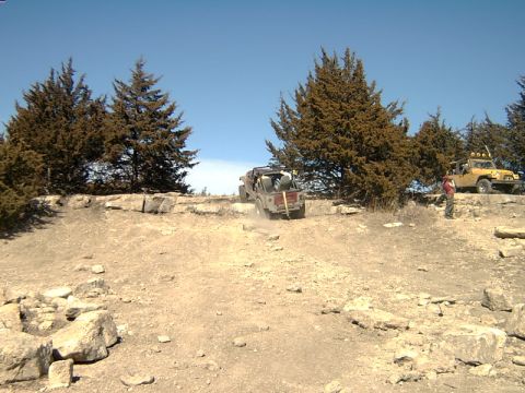 1998 Jeep TJ - Two Jeeps navigate a challenging off-road course under a clear blue sky.