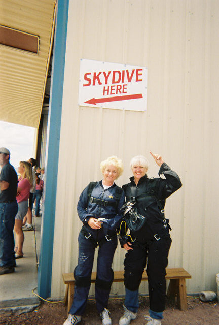 1972 Ford Ranchero - Two women in skydiving jumpsuits pose for a photo near a sign indicating the skydiving location.