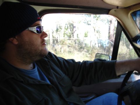 1989 Ford Bronco - Interior view of a man driving an older SUV on a wooded road.