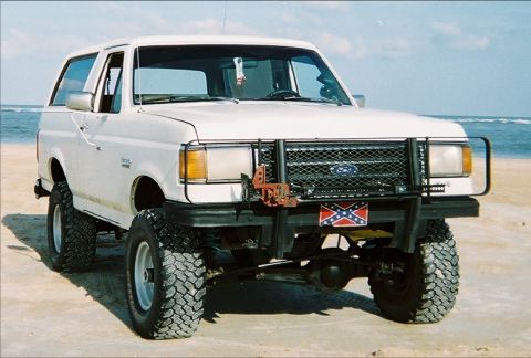 1989 Ford Bronco - This lifted 1987 Ford Bronco is parked on a sandy beach with the ocean in the background.