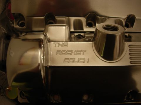 1992 Ford Crown Victoria - A close-up of a shiny chrome engine component, engraved with the words "THE ROCKET COUCH".