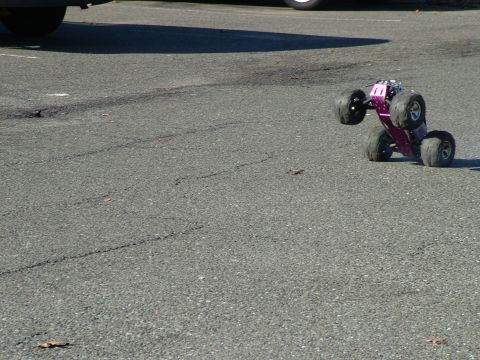 1994 Ford Bronco - A remote control monster truck is tipped over on a paved surface.