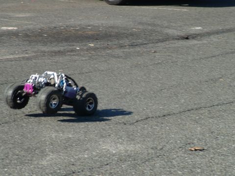 1994 Ford Bronco - RC monster truck airborne on asphalt surface.