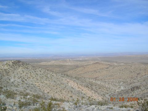 1985 Ford Bronco - A wide view of a dry, hilly desert landscape under a blue sky with wispy clouds, dated January 28, 2006.