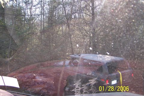 1979 Ford Bronco - A 1979 Ford Bronco is stuck in the mud, seen from the rear quarter angle.