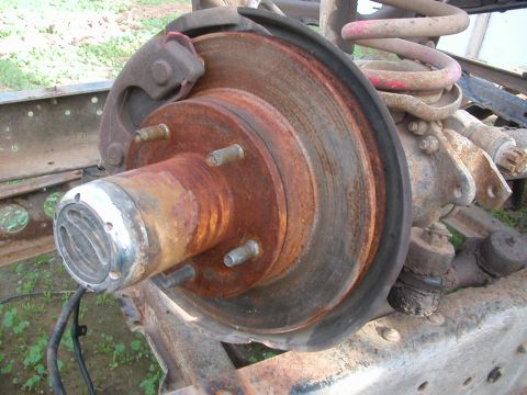 1984 Ford Bronco - Close-up view of a heavily rusted brake rotor and hub assembly, likely from an older vehicle undergoing restoration or repair.