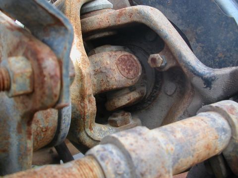 1984 Ford Bronco - This image shows heavily rusted suspension components, with a "SUPERMOTORS" watermark visible.