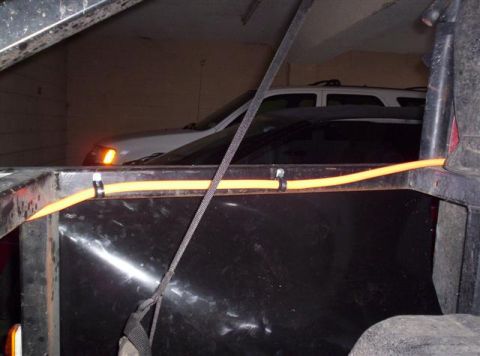 1987 Suzuki Samurai - A white SUV and another vehicle are parked closely together inside a dimly lit garage.