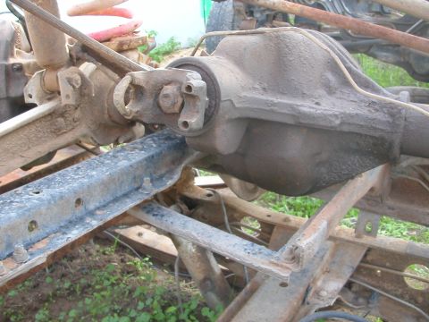 1984 Ford Bronco - Close-up view of a vehicle's rear axle and driveshaft, indicating a part of the chassis undergoing work or repair.