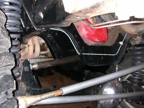 1984 Ford Bronco - A close-up view of a vehicle's undercarriage reveals its mechanical components and suspension system.