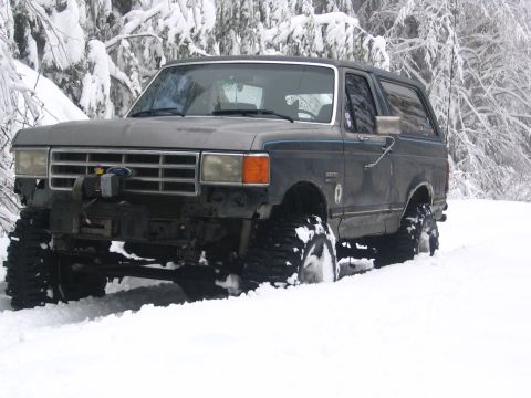 1987 Ford Bronco - This 1987 Ford Bronco is equipped with large tires and a winch, ready for off-road adventures in the snow.