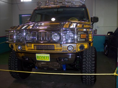 1972 Ford Ranchero - Front view of a yellow Hummer H2 with extensive chrome detailing and off-road tires.