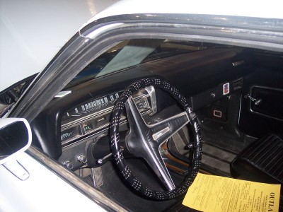 1972 Ford Ranchero - The dashboard features a horizontal speedometer and various gauges. A yellow document rests on the passenger seat.