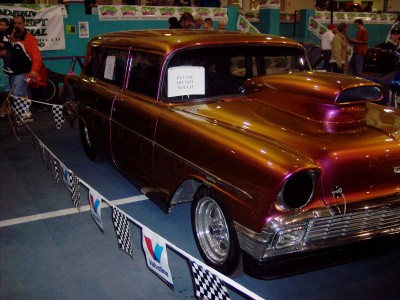 1972 Ford Ranchero - A customized station wagon with a prominent hood scoop and iridescent paint is displayed indoors.