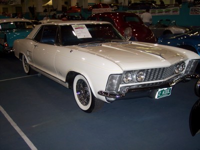 1972 Ford Ranchero - A white coupe is displayed indoors, with other vehicles visible in the background.
