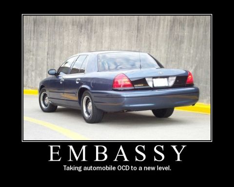 1998 Ford Crown Victoria - A dark blue sedan is parked in front of a concrete wall, with text overlaying the image.