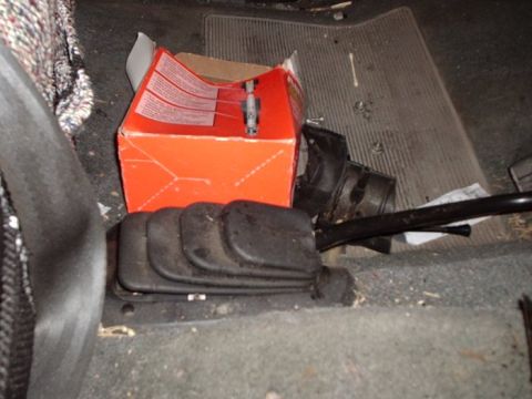 1990 Ford Bronco - The interior of a vehicle shows a gear shifter and an orange box on the floor.