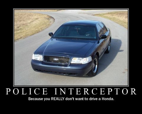 1998 Ford Crown Victoria - A dark blue 1998 Ford Crown Victoria Police Interceptor is shown from the front 3/4 angle on a paved road.
