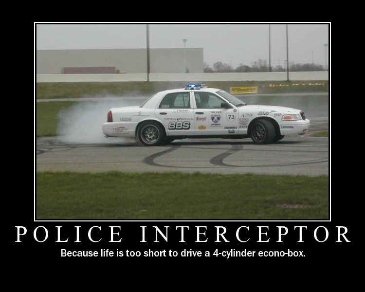 White Crown Victoria sedan with sponsor decals and roof light bar doing a smoky burnout on a track.