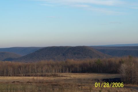 1979 Ford Bronco - A wide view of a natural landscape with rolling hills and a prominent rounded hill in the distance.