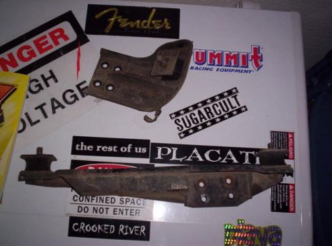 1987 Suzuki Samurai - Metal automotive parts are displayed on a sticker-covered surface, not a 1987 Suzuki Samurai.