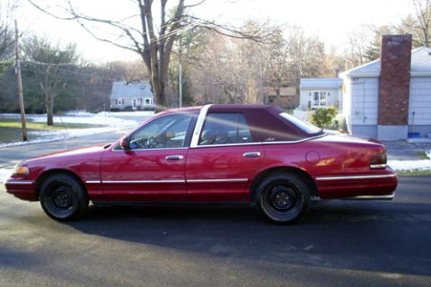 2000 Ford Crown Victoria - Side profile of a red 2000 Ford Crown Victoria sedan a burgundy vinyl roof.