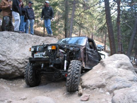 1981 Ford Bronco - Modified 1981 Ford Bronco navigating a rocky trail with spectators present.