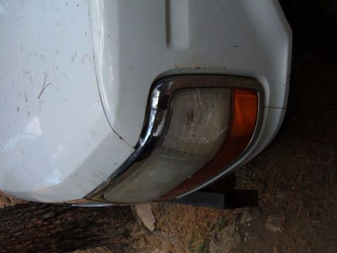 1993 Ford Bronco - Rear tail light assembly on a white vehicle, showing chrome trim and amber turn signal.