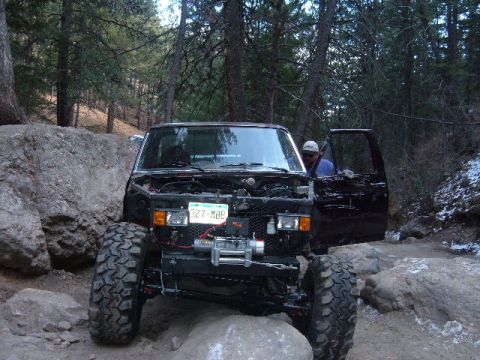 1993 Ford Bronco - A modified 1993 Ford Bronco navigates a rocky trail with its hood open and a winch installed.