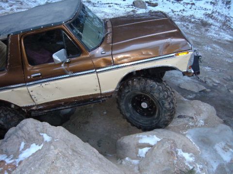 1993 Ford Bronco - This Ford Bronco is tackling a rocky trail with snow on the ground.