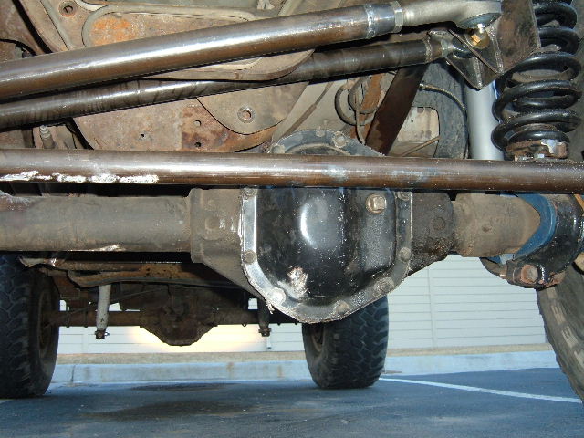 Underbody view of a vehicle showing differential, suspension arms, and coil spring