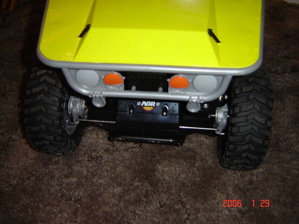 Yellow toy RC car front with silver bumper, orange lights, and AGR logo