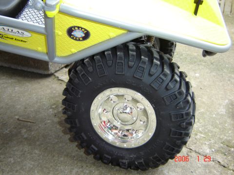 1993 Ford Bronco - A close-up shot focuses on the aggressive tire and chrome wheel of a custom off-road vehicle.